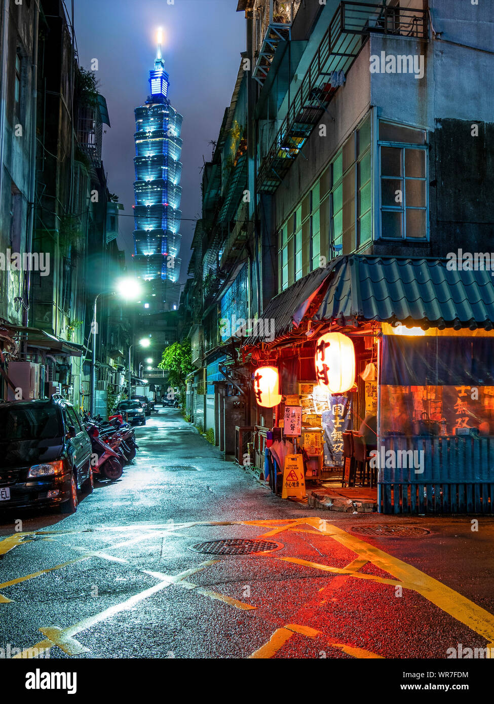 Street to Taipei 101 with japanese corner restaurant at night Stock Photo
