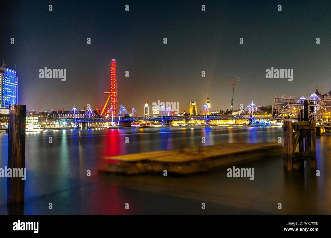 Illuminated Golden Jubilee Bridge Over Thames River At Night Stock Photo
