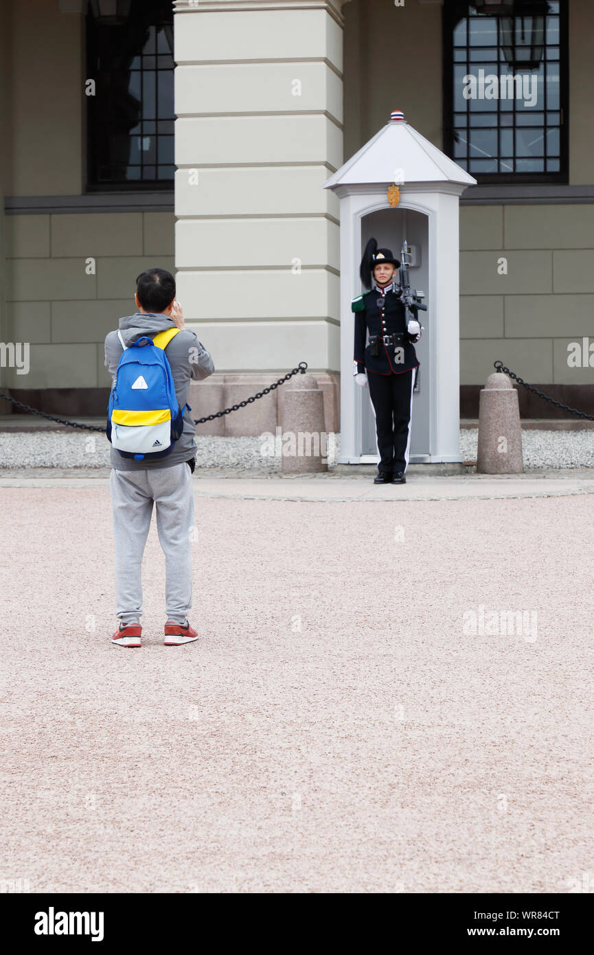 Oslo, Norway - June 20, 2019: A tourist taking photos of the royal guard at the Oslo royal palace. Stock Photo