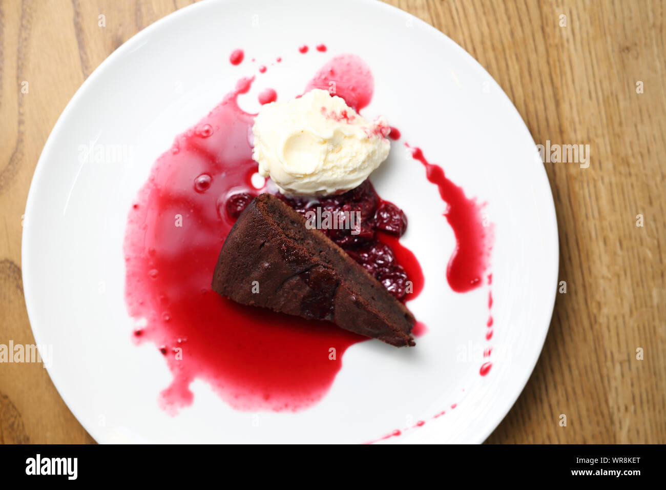 Brownie with raspberry sauce and ice cream. Stock Photo