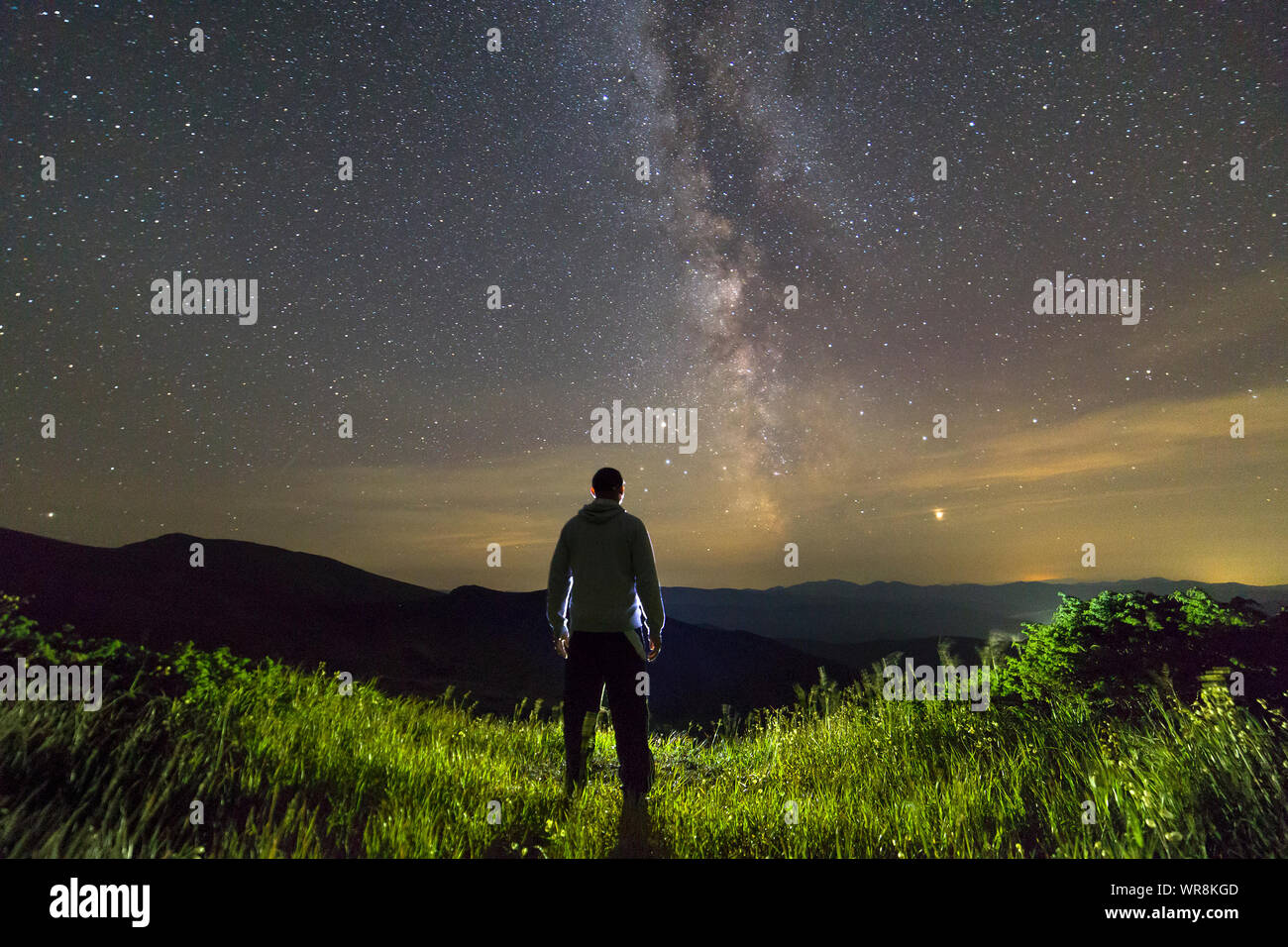 Dark silhouette of a man standing in mountains at night enjoying milky way view Stock Photo - Alamy