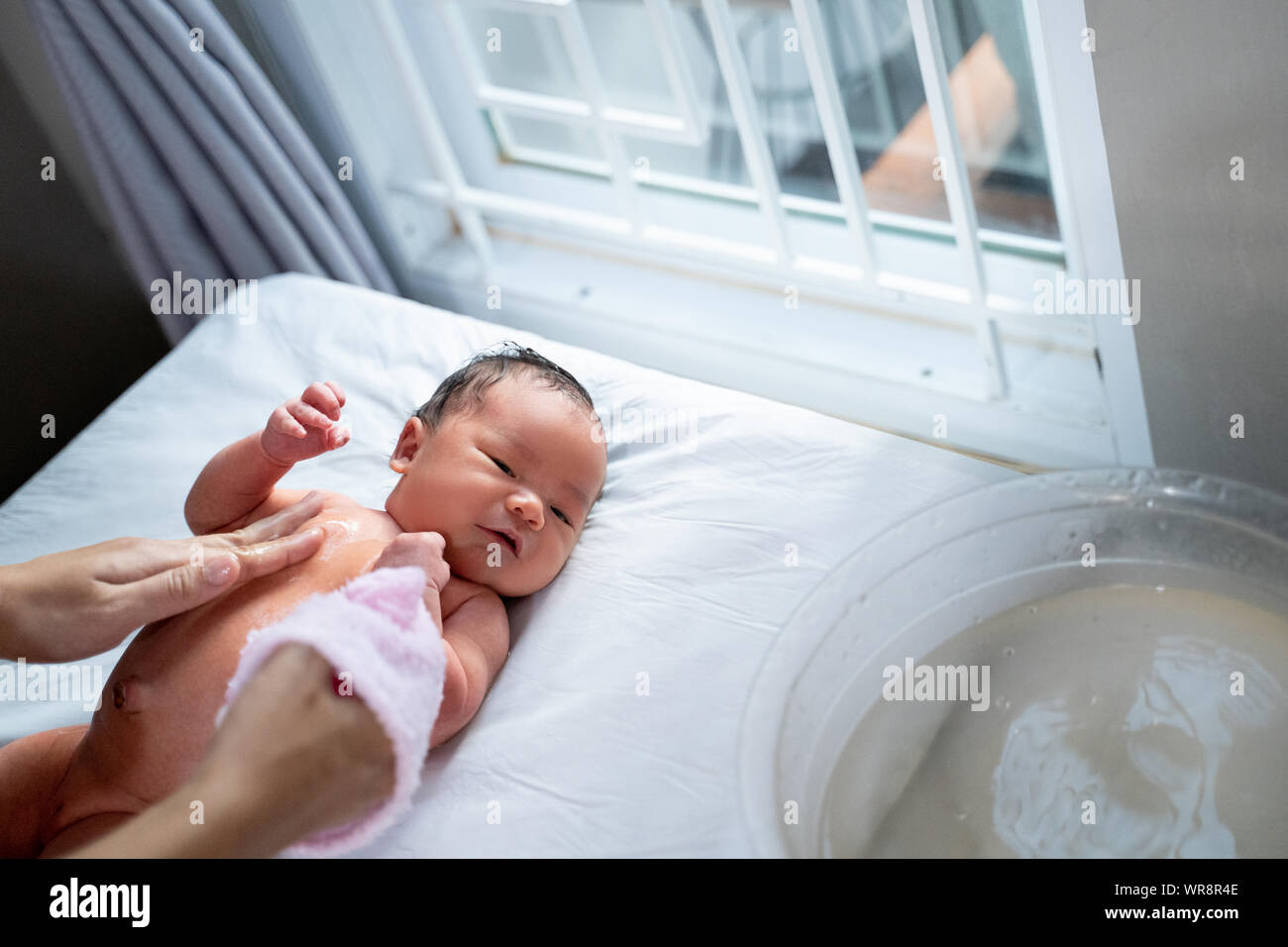 newborn bay bath using wet towel with mother Stock Photo Alamy