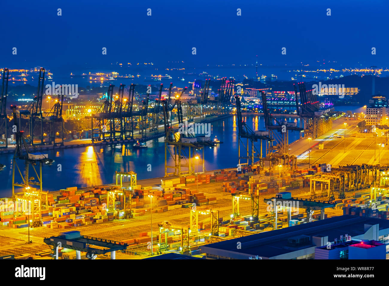 Logistics and transportation of container Cargo ship with working crane bridge in shipyard at twilight time. Stock Photo