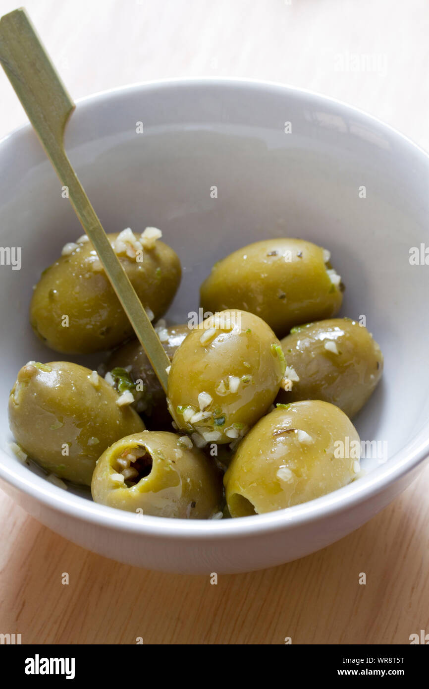 Green olives with garlic in white bowl Stock Photo Alamy