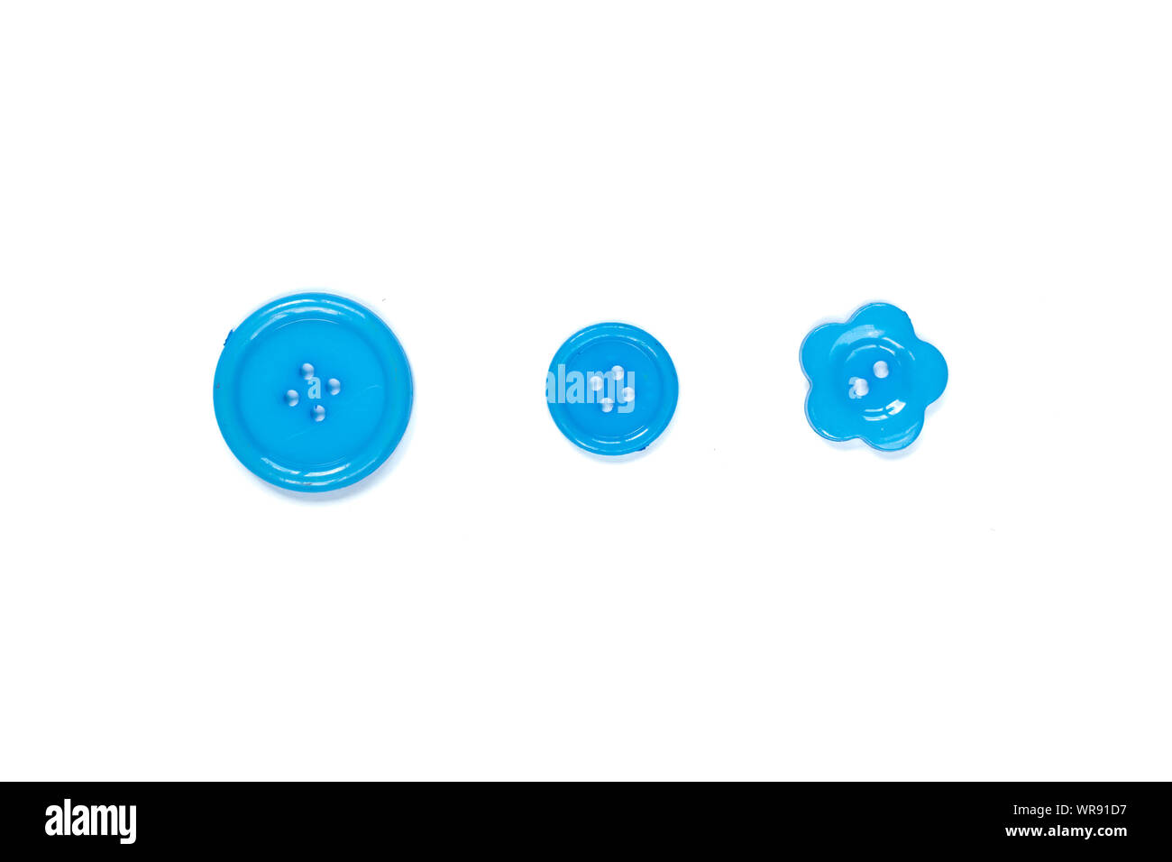 Three Various blue sewing buttons isolated on background. Stock Photo