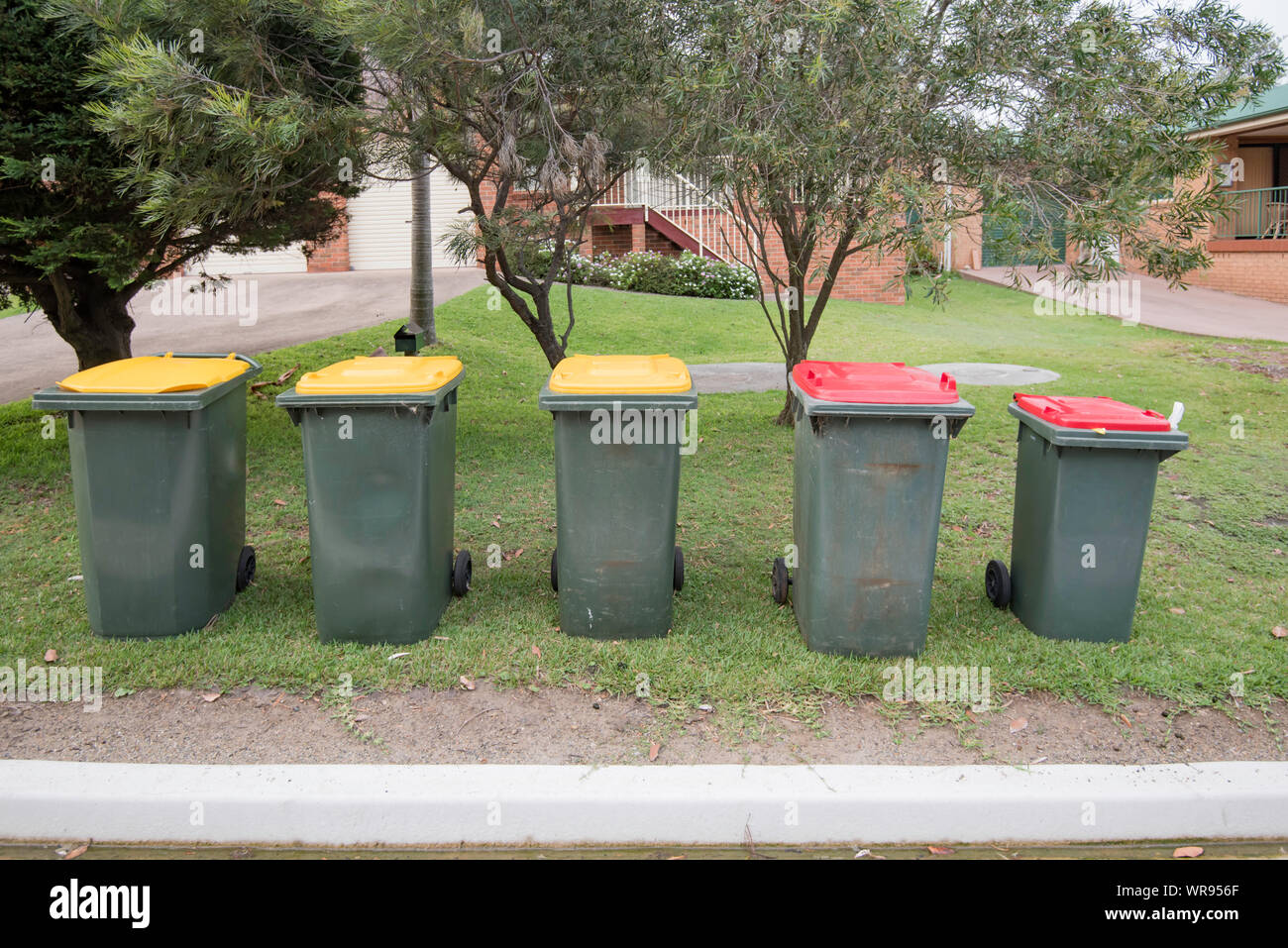 Red top rubbish and yellow top recycling bins await collection outside homes in Kioloa on the South Coast of New South Wales, Australia Stock Photo