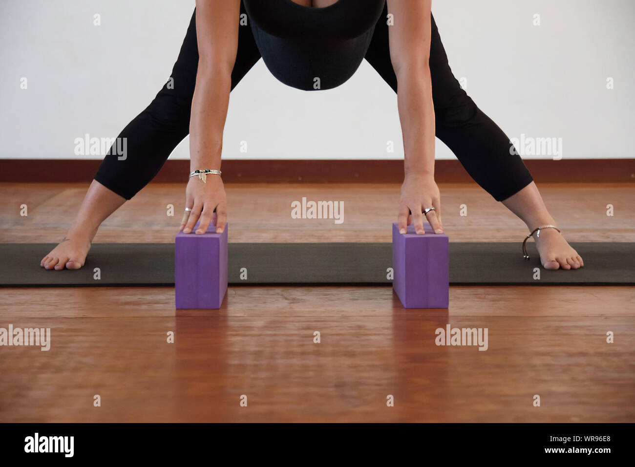Low Section Of Pregnant Woman Exercising On Hardwood Floor Stock