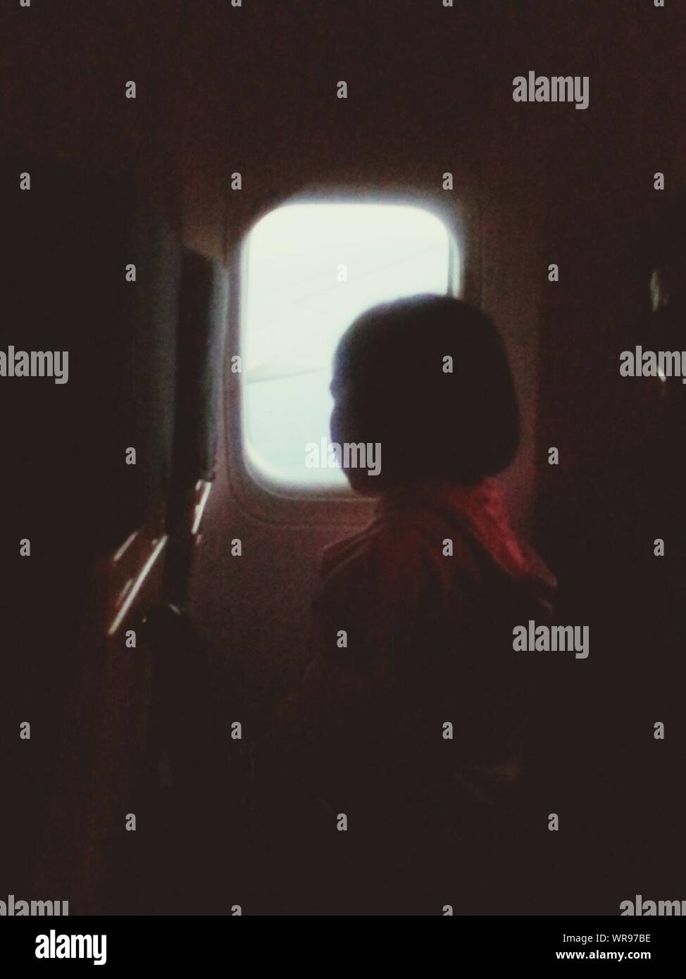 Young Girl Looking Out Airplane Window Stock Photo