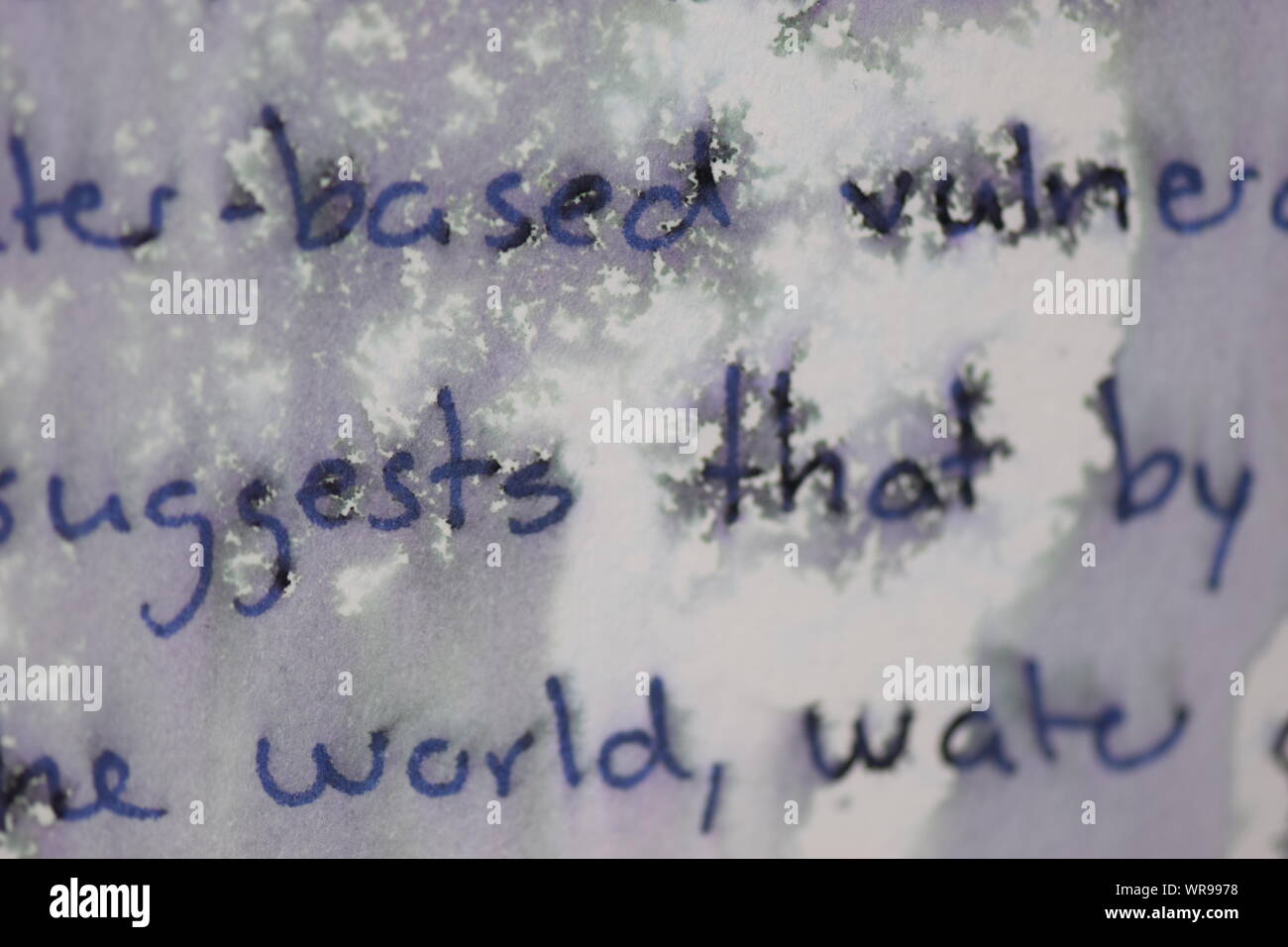 Handwritten text on paper sprinkled with water to create a mosaic