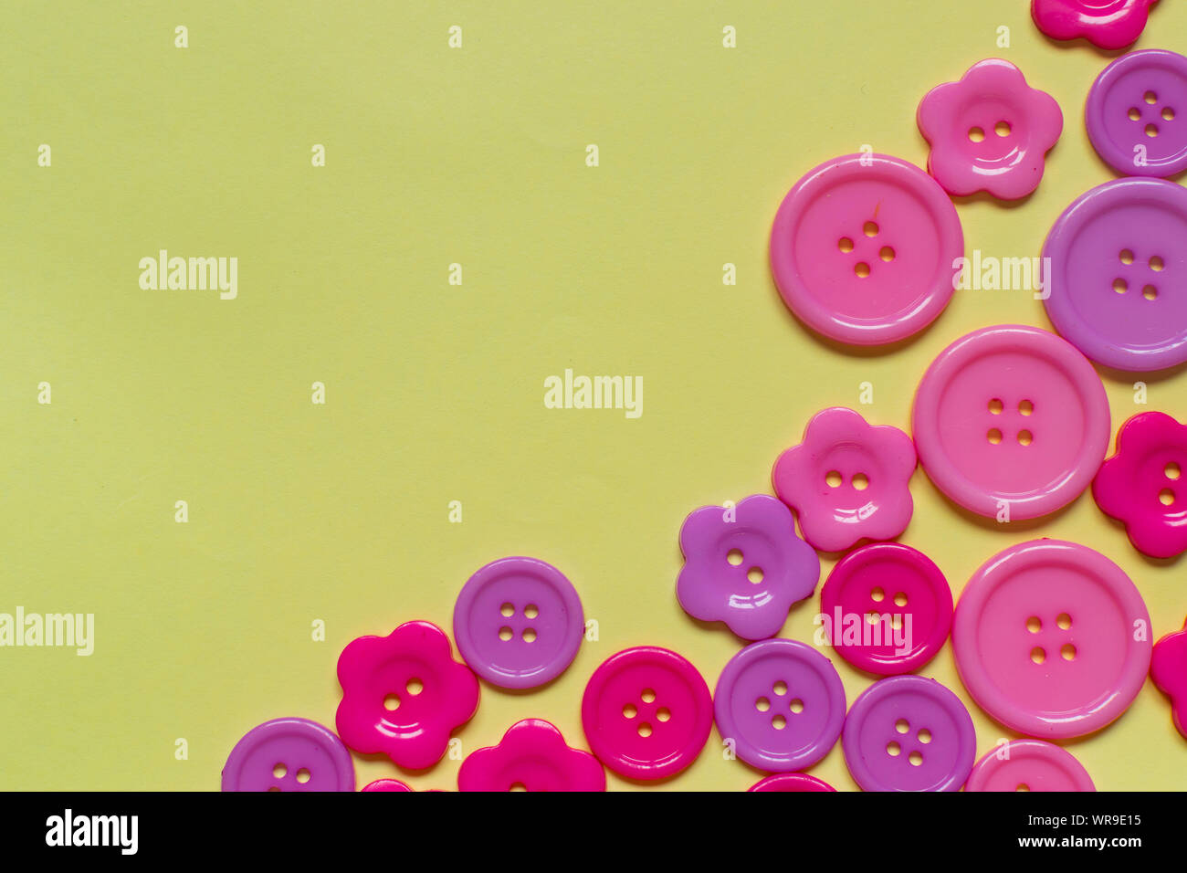 Various Pink Sewing Buttons On Light Yellow Background With Place