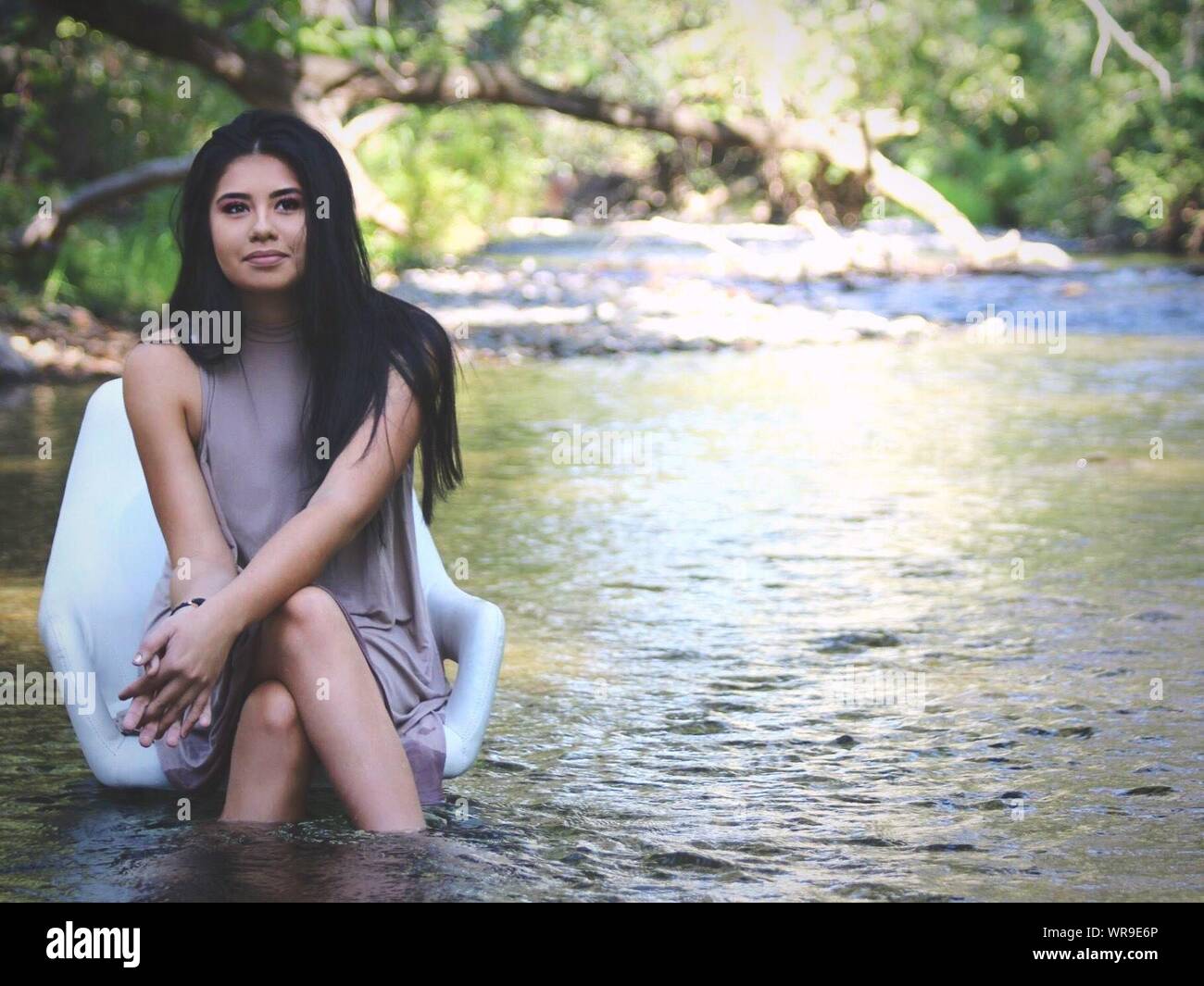 Portrait Of Young Woman Sitting In Water Stock Photo - Alamy