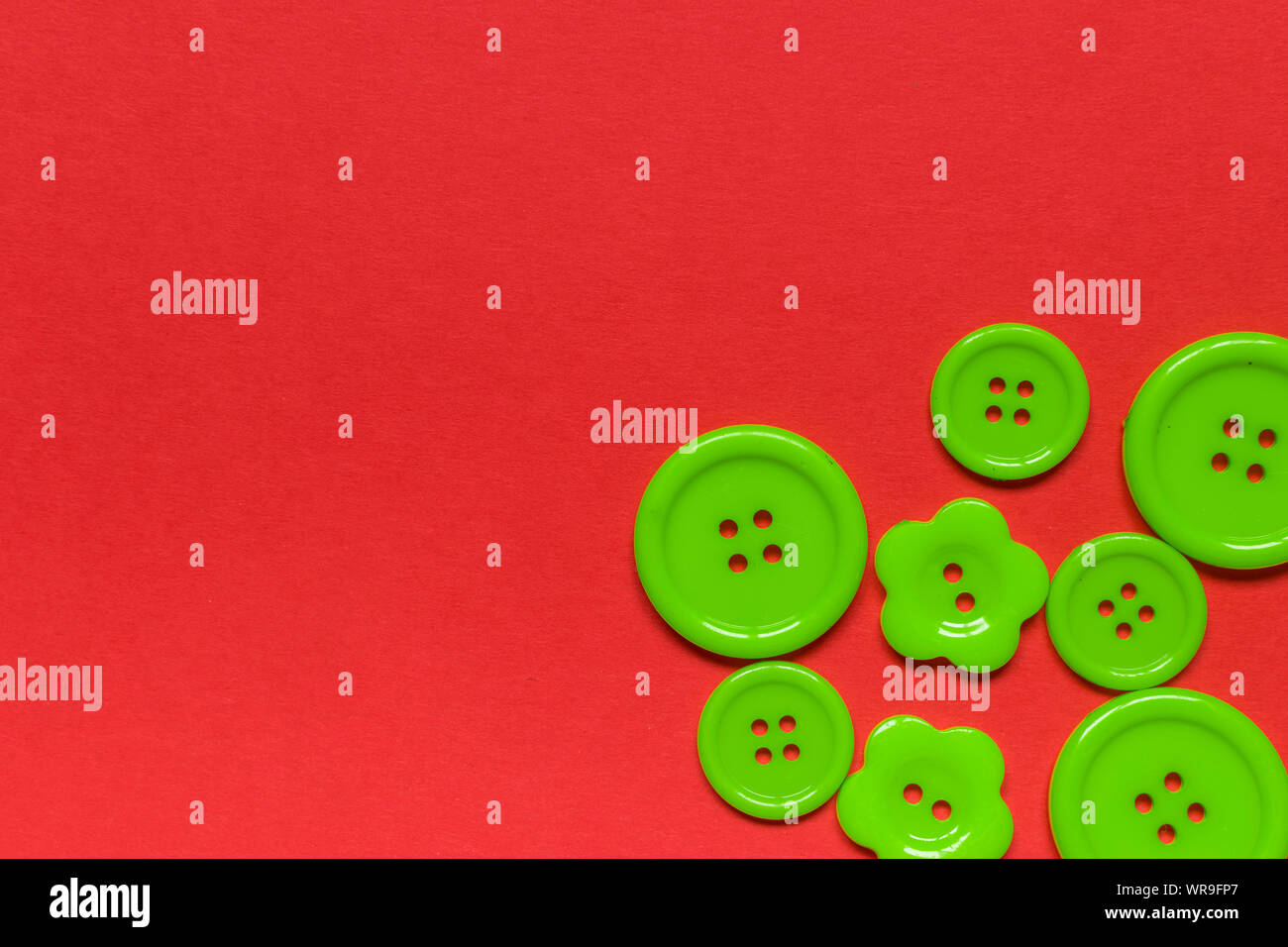 Various green sewing buttons on red background with place for text ...