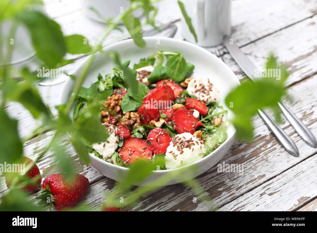 Salad with strawberries, ricotta cheese and green lettuce with walnuts