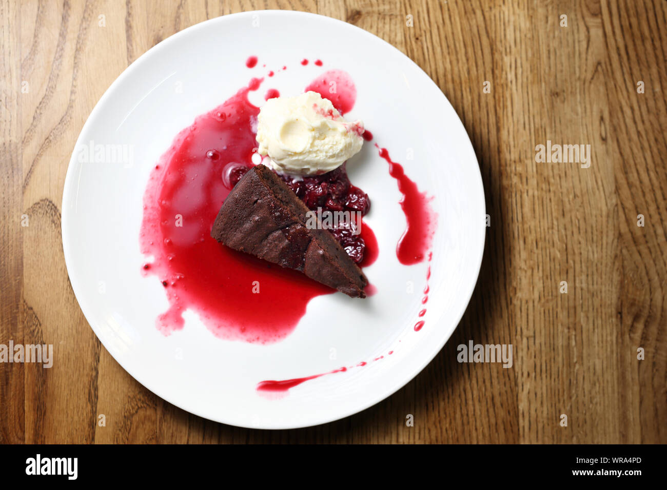 Chocolate brownie with raspberry sauce and ice cream. Stock Photo