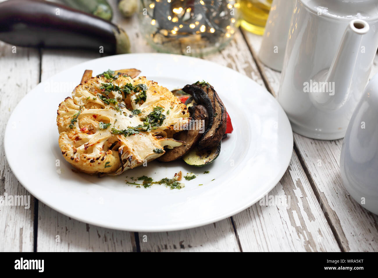 Baked cauliflower with mushrooms served with herbs. Stock Photo