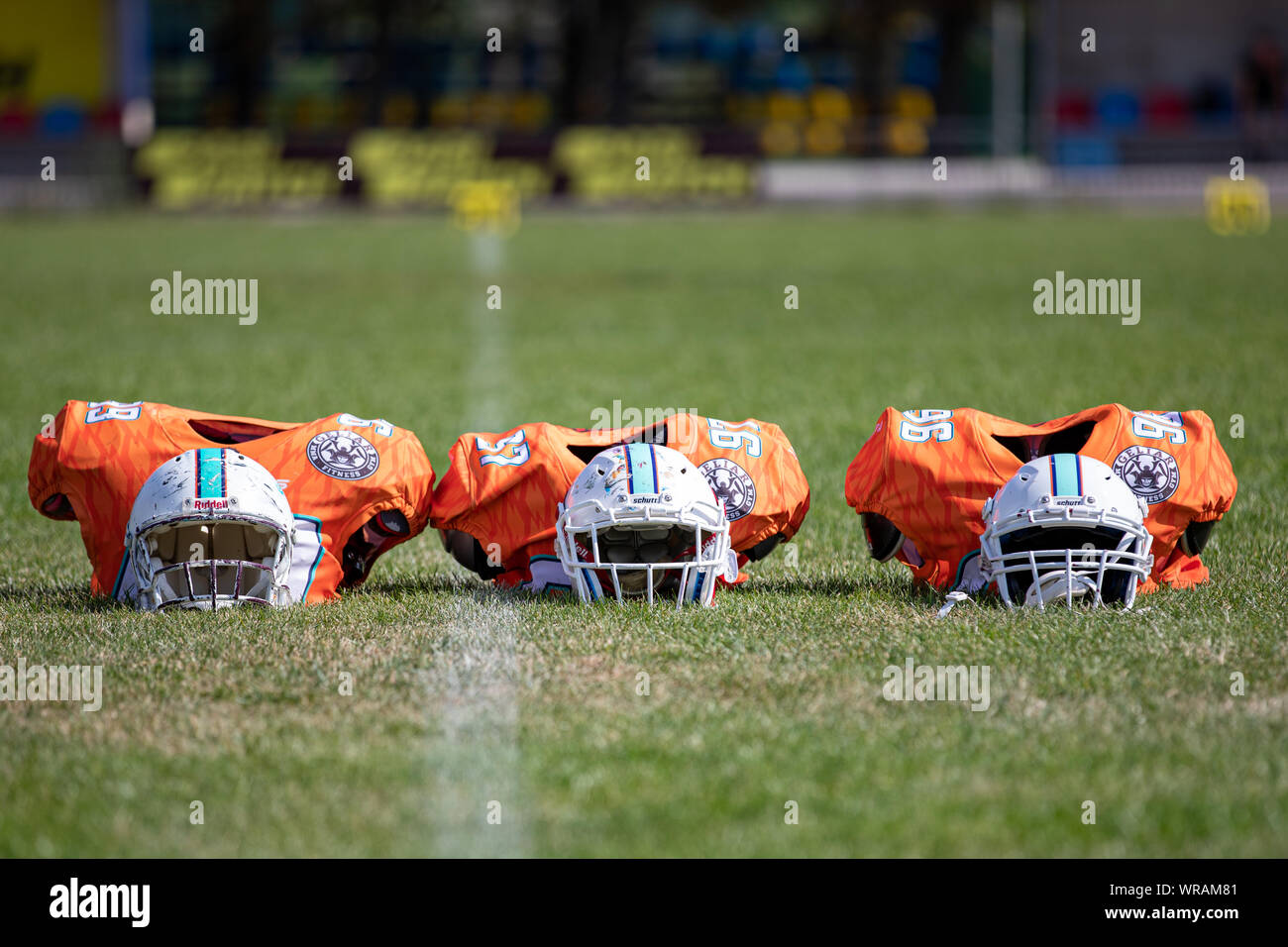 Close up of sports jersey with helmets on american football playing field background. american football competitions Stallions Kyiv - Hurricanes Minsk Stock Photo