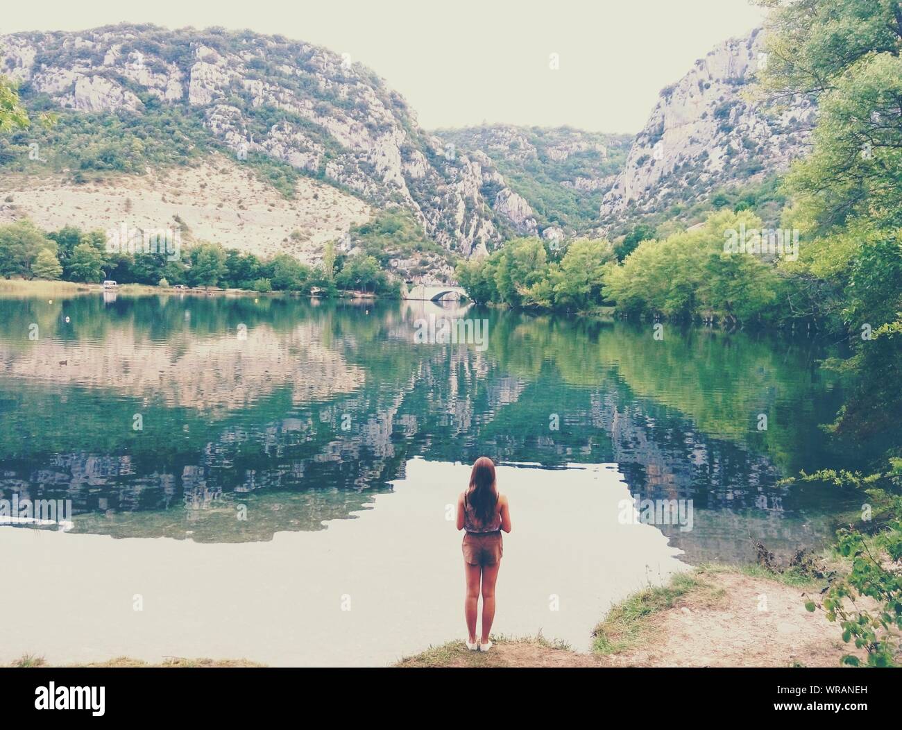 Rear View Of Woman Standing Lakeshore Stock Photo - Alamy