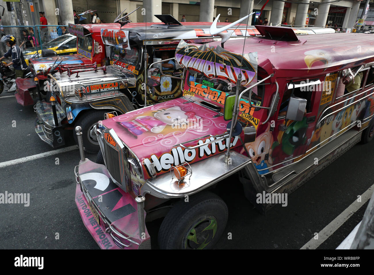 Manila, Philippines. 31st July, 2019. A jeepney drives through the capital of the Philippines. Jeepneys are originally converted military jeeps that were left behind by the US army after the Second World War. The Filipinos rebuilt them and used them as taxis. The demand for these vehicles is still so great that they are now completely handcrafted. The cars are painted at the end with a lot of attention to detail and are then true art galleries on wheels. Credit: Alejandro Ernesto/dpa/Alamy Live News Stock Photo