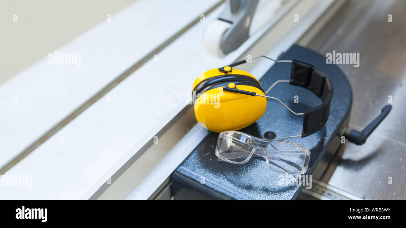Occupational safety Protective glasses and hearing protection on circular saw in the