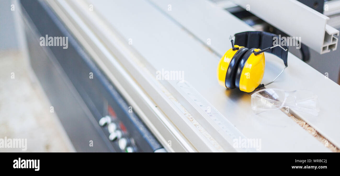 Occupational safety Protective glasses and hearing protection on circular saw in the