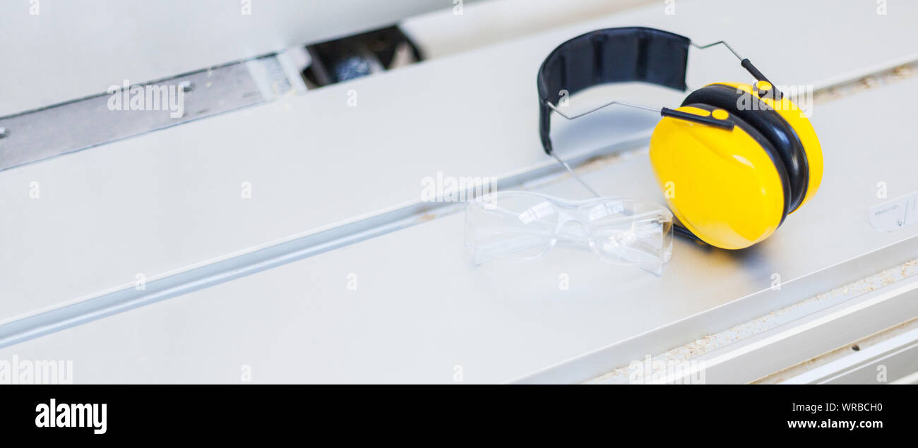 Occupational safety Protective glasses and hearing protection on circular saw in the