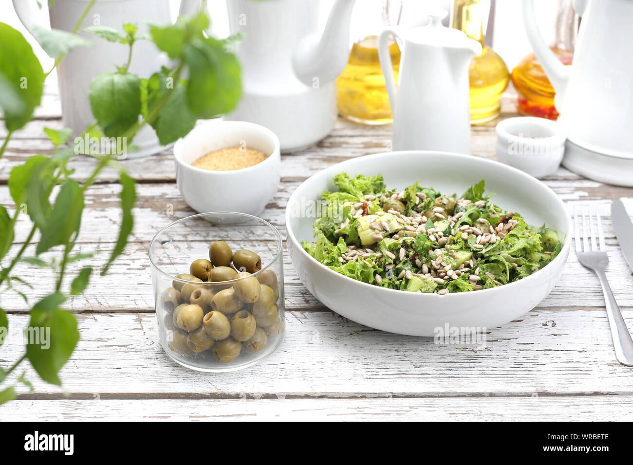 Fresh salad with olives, sun-dried tomatoes, sunflower seeds served with a sauce based on oil and herbs. Stock Photo