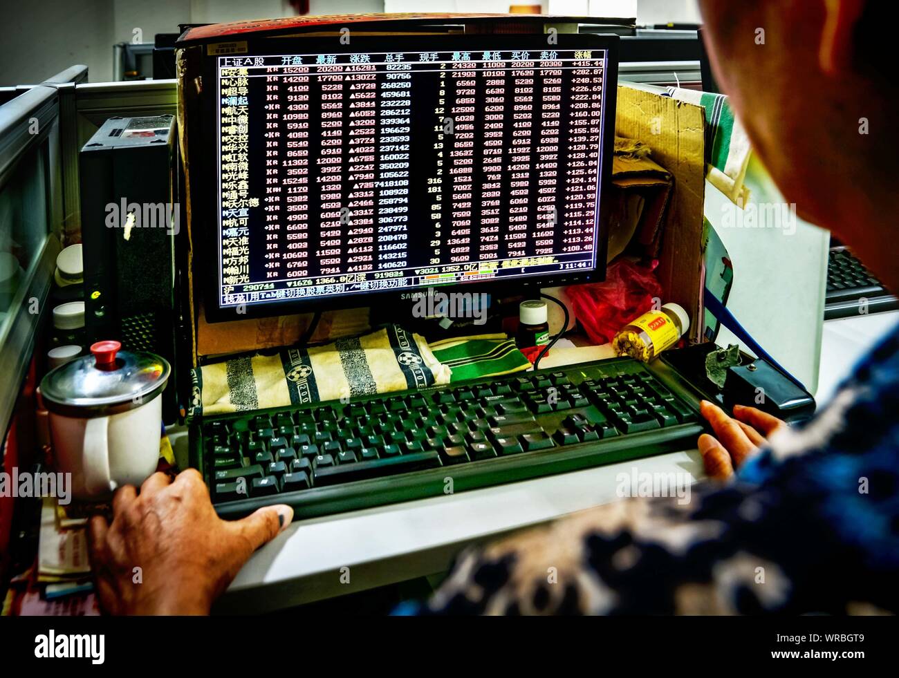 A Chinese investor watches the prices of shares being traded on the SSE
