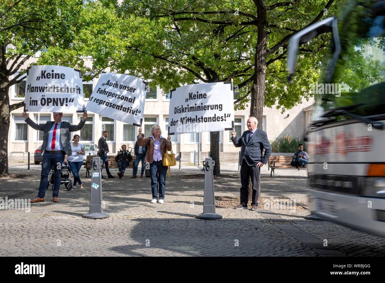 Hanover, Germany. 10th Sep, 2019. Demonstrators hold up signs with demands such as 'No planned economy in public transport', 'Our drivers are also representative' and 'No discrimination against SMEs' while a bus passes by. Private bus operators have criticised the transport policy of the state government of Lower Saxony. More than 70 buses with inscriptions like 'Der Mittelstand darf nicht sterben' drove around the state parliament in Hanover several times on Tuesday afternoon. Credit: Sina Schuldt/dpa/Alamy Live News Stock Photo