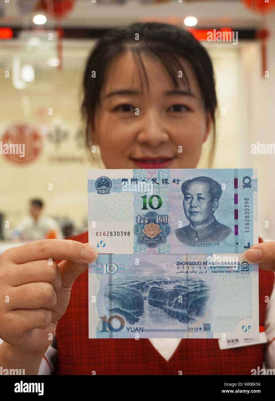 A Chinese Employee Shows 10 yuan Banknotes Of The 2019 Edition Of The a-chinese-employee-shows-10-yuan-banknotes-of-the-2019-edition-of-the