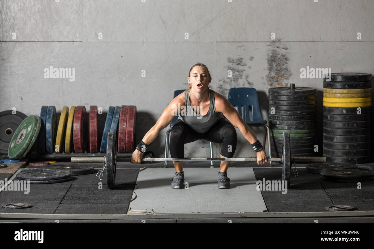 Young woman lifting heavy weights in grungy gym Stock Photo Alamy