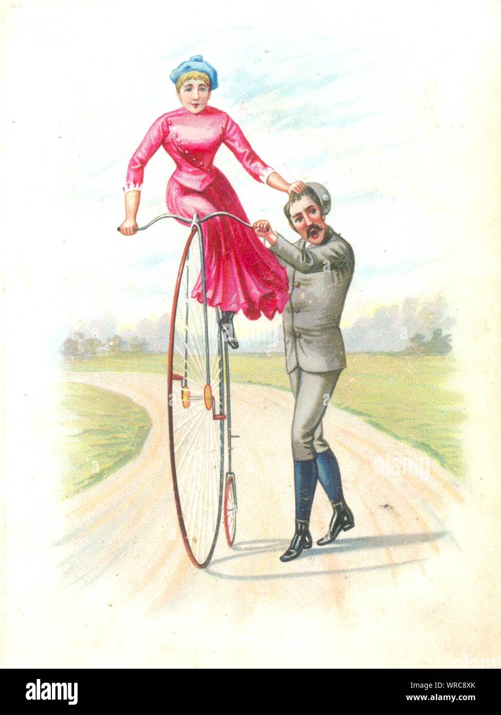 Man trying to teach woman to ride a Penny Farthing bicycle 1895 Stock Photo