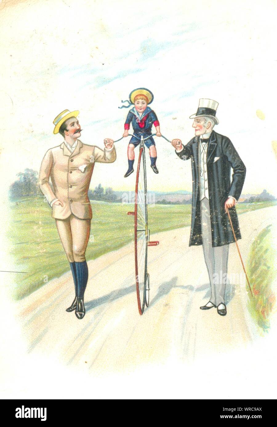 Grandfather and father helping son to balance on  a Penny Farthing bicycle Stock Photo