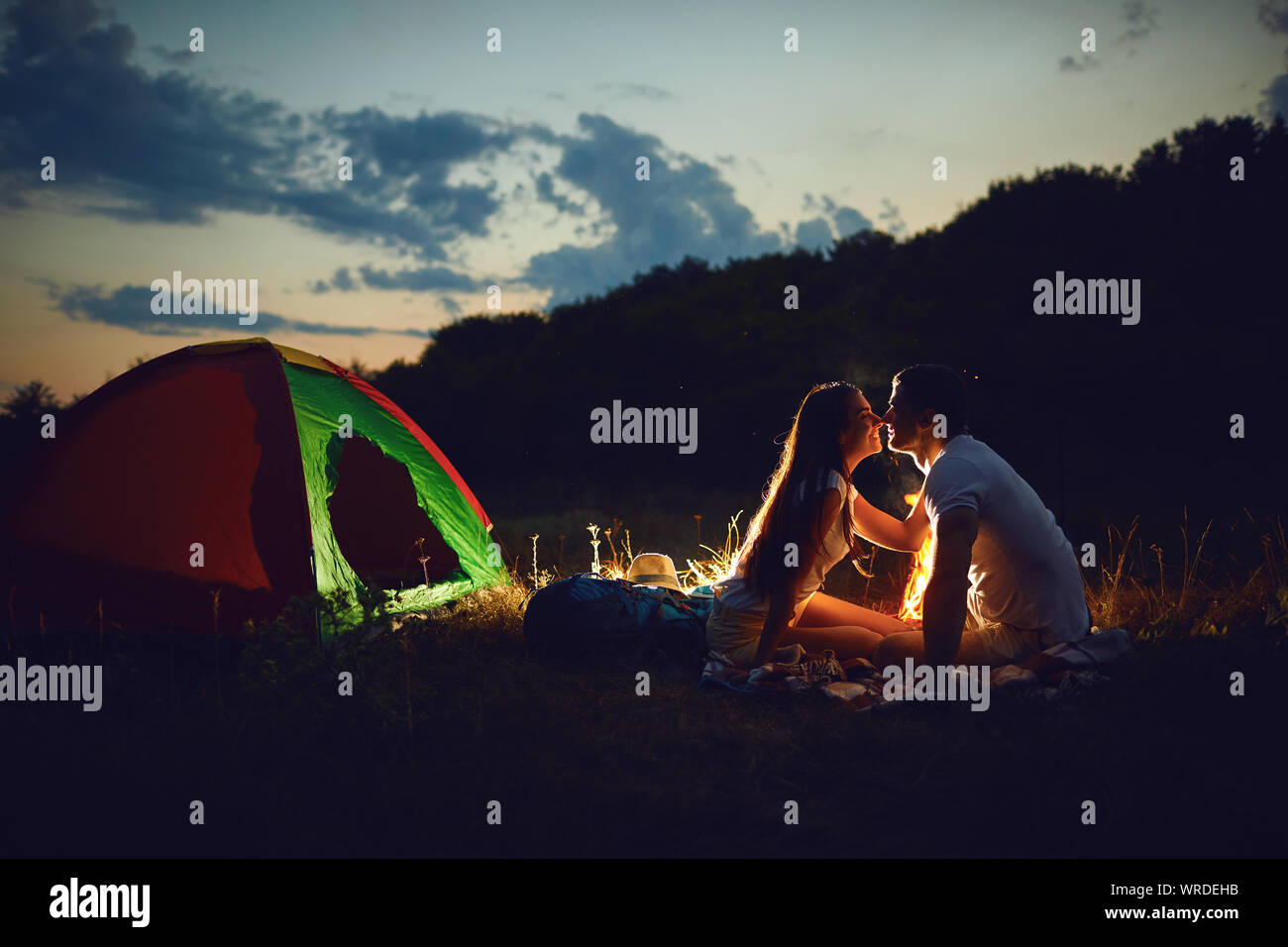 Romantic Camping A Young Couple Sitting By The Bonfire Stock Photo Alamy