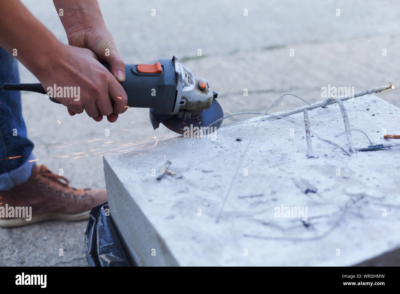 Woman separates metal with a cutoff wheel. Onehanded angle grinder