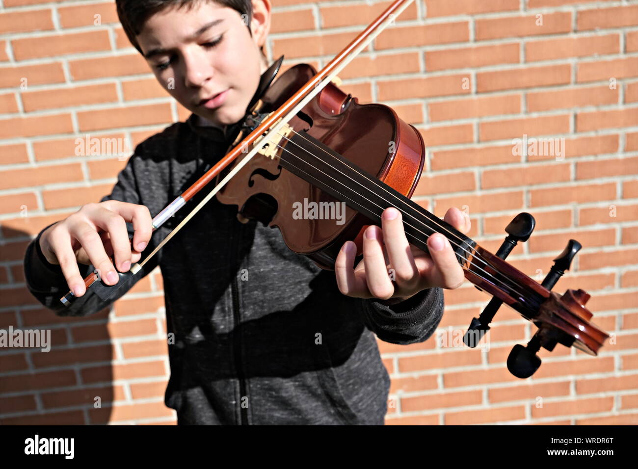 teenager playing violin with shallow depth of field Stock Photo