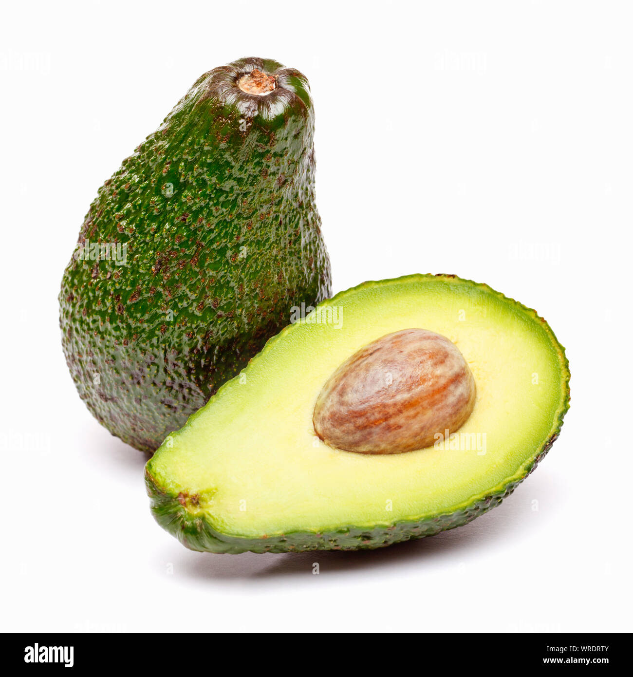 Avocados, whole and sliced in half on a white background Stock Photo