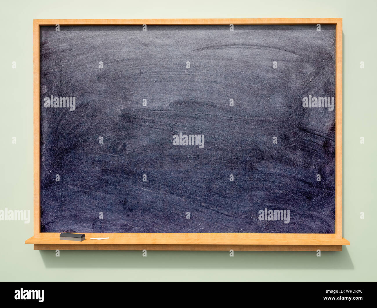 Large wall mounted blank school blackboard or chalkboard with chalk and eraser Stock Photo
