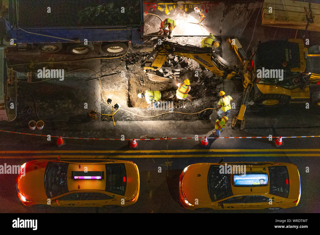 City workers at a night worksite repairing infrastructure, New York City, USA Stock Photo