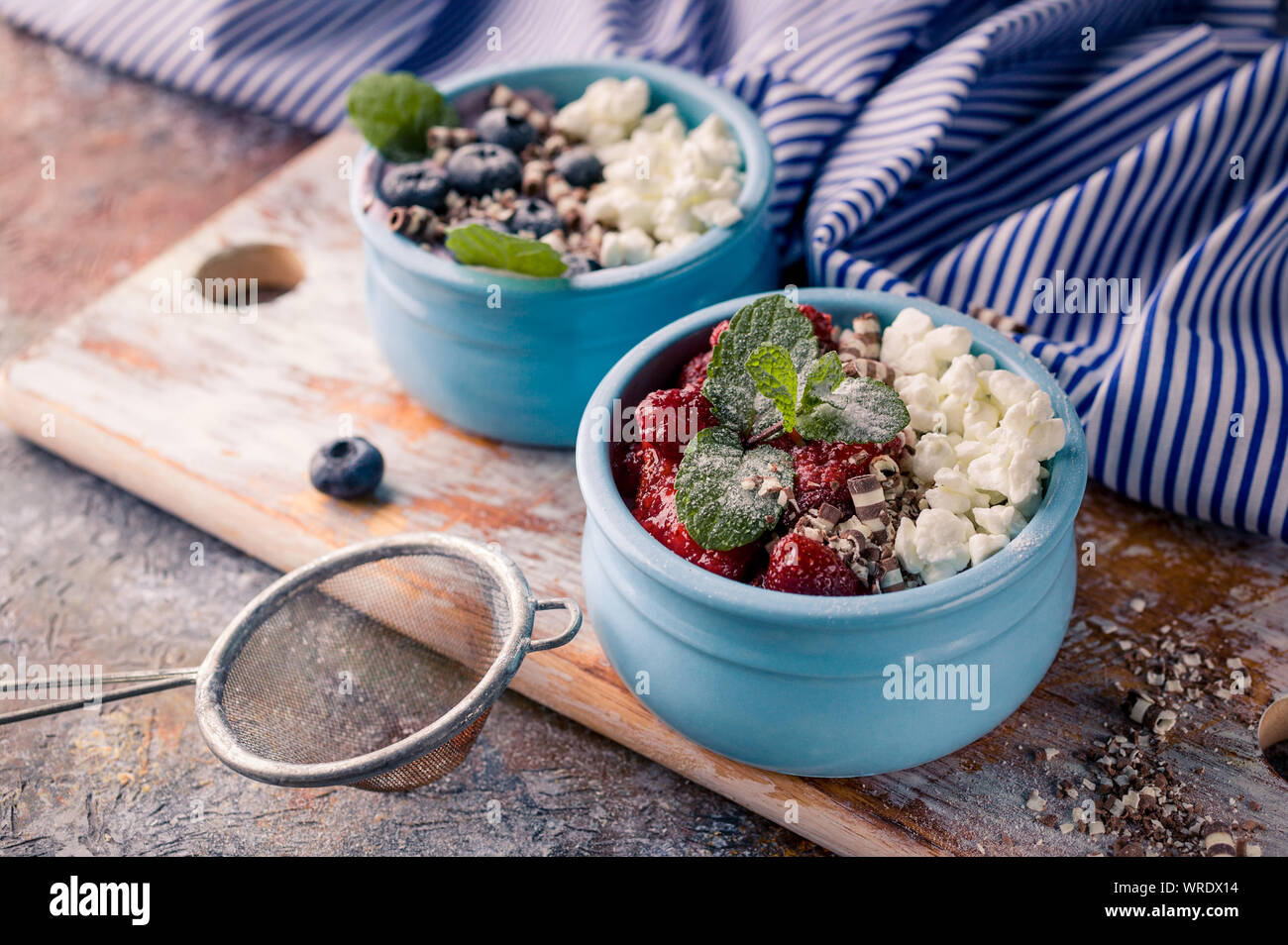 Cottage sweet dessert with jam in blue deep bowl, Strawberry jam and blueberries Stock Photo