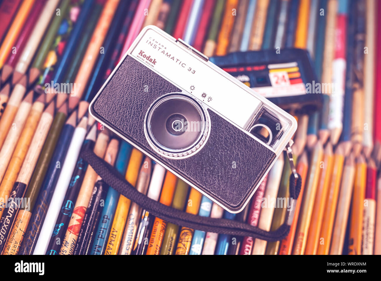 Old camera on top of old pencils, concept image of old and outdated but retro fashion. Stock Photo
