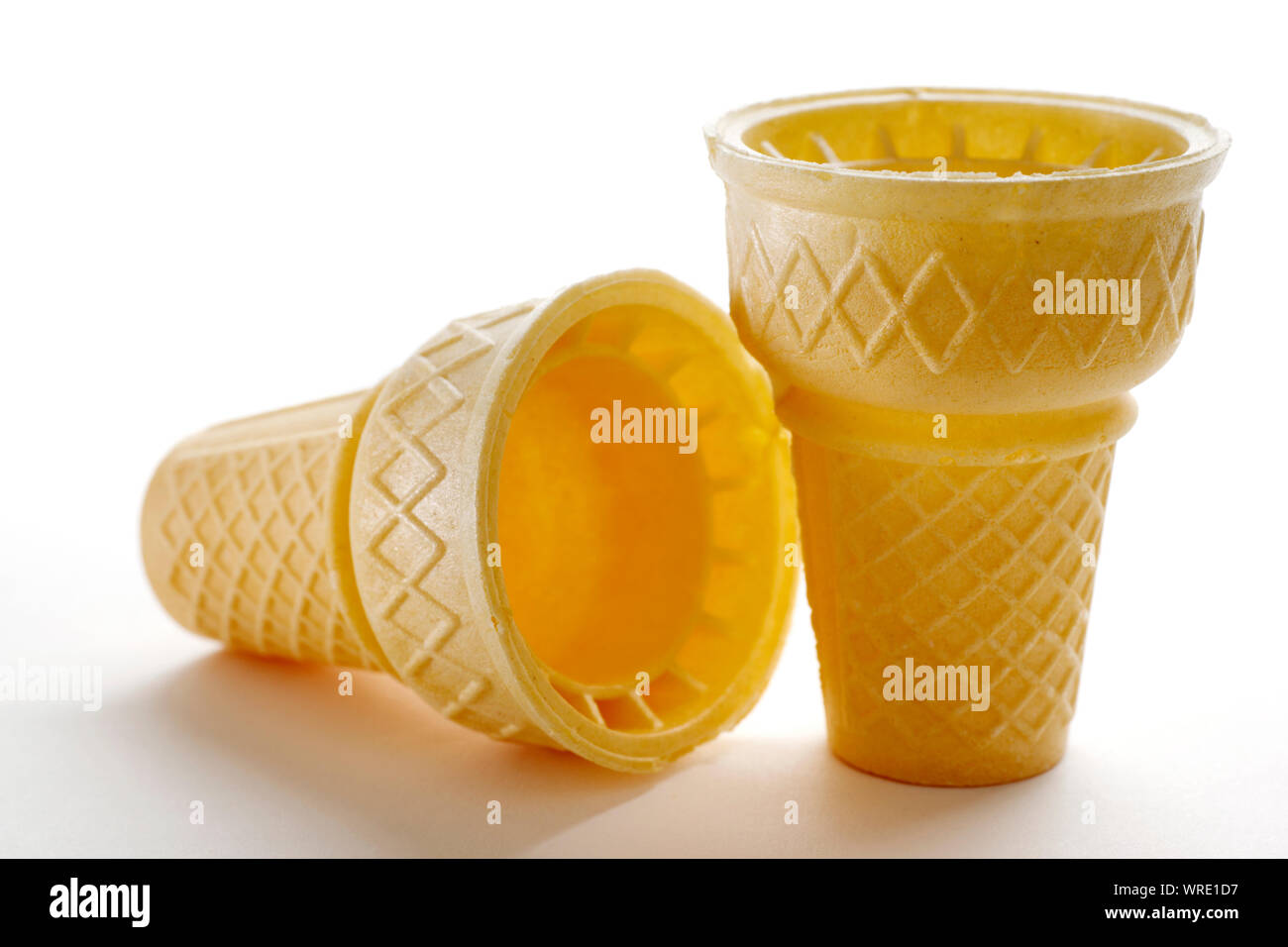 Two empty ice cream cones,one lying on its side and one standing upright, isolated on white background Stock Photo