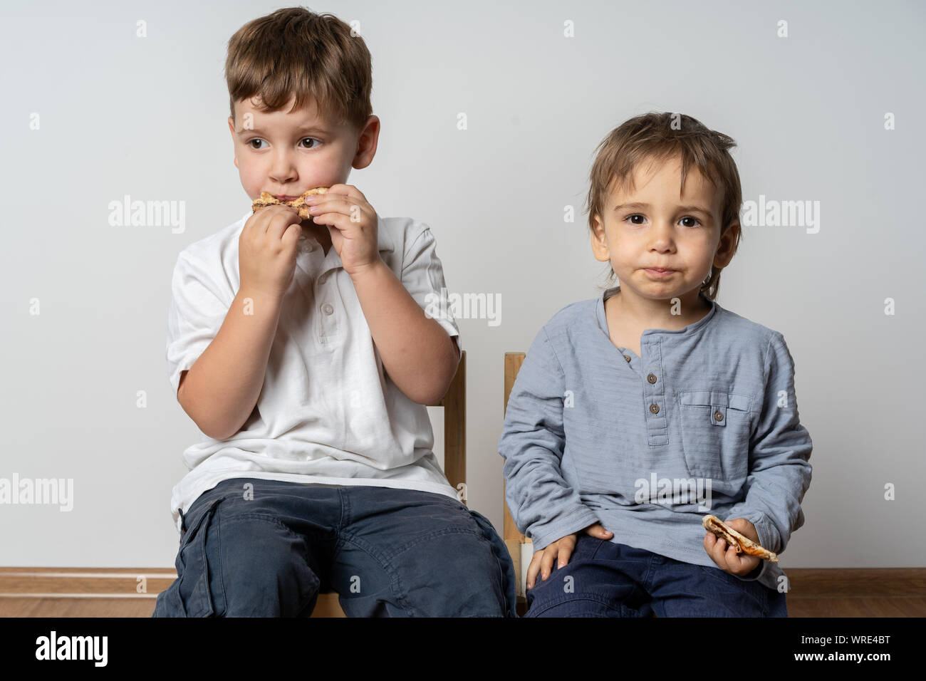 Children sitting at cafeteria table while eating lunch. Smiling kids ...