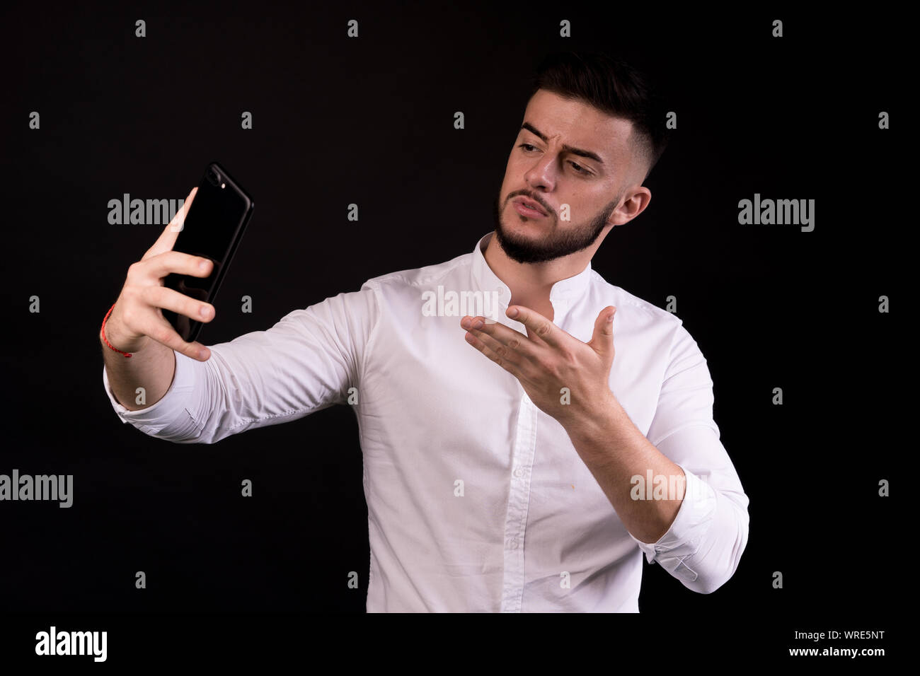 Business man taking selfie from phone on black background. Concept - video dialogue. Stock Photo