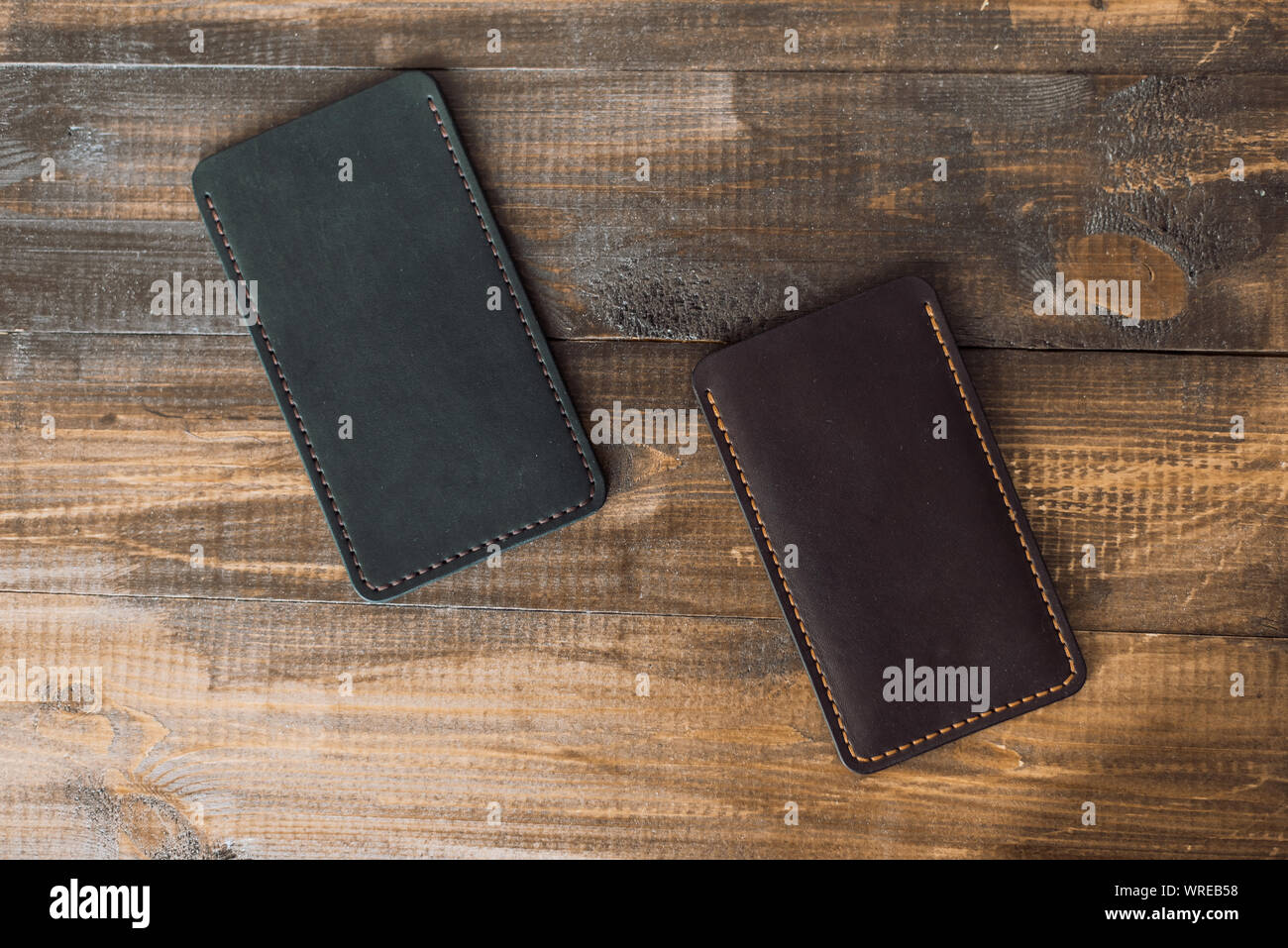 leather luxury phone cases on a wooden background. Beautiful genuine leather phone cases. Stock Photo
