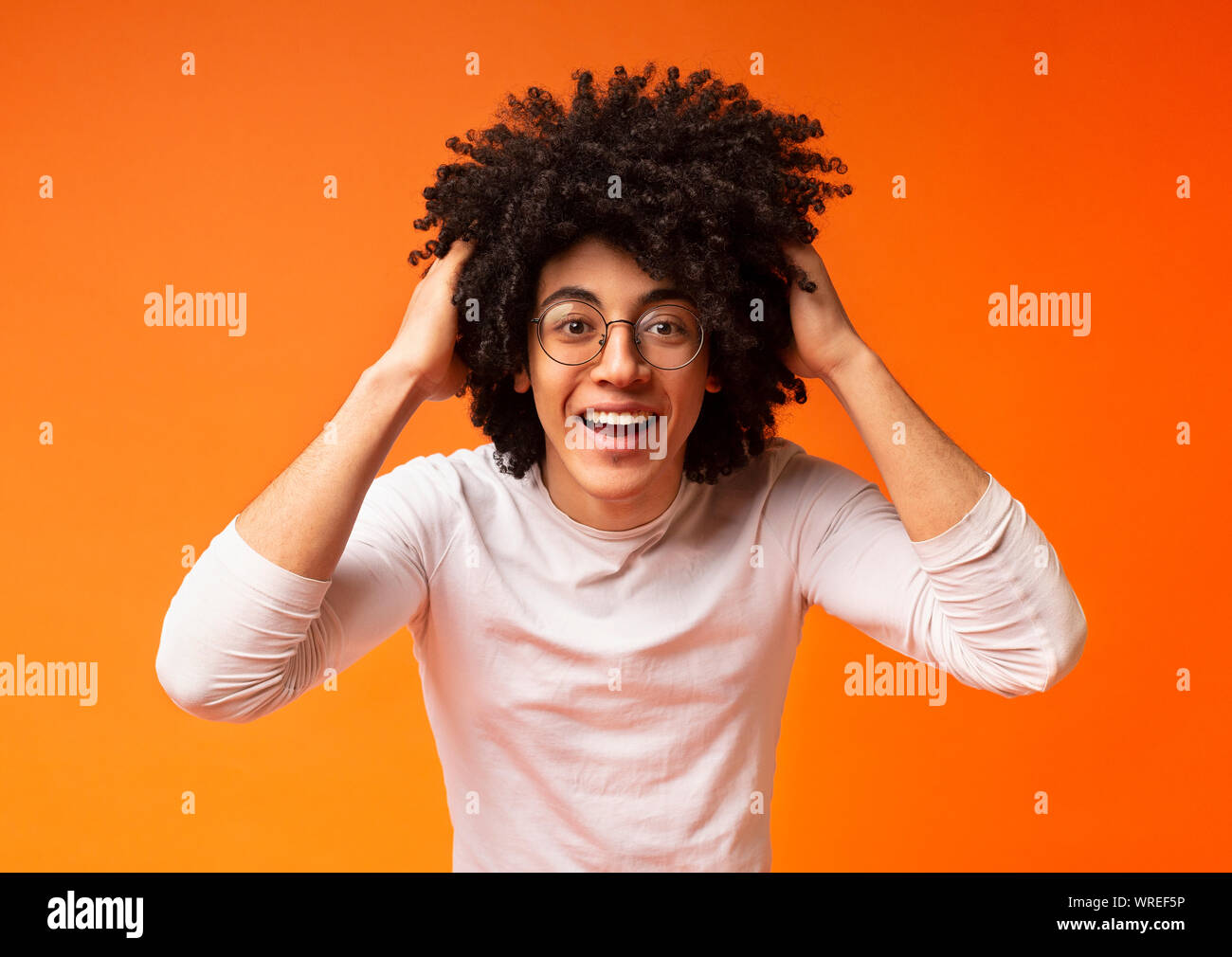 Emotional Surprised Young Black Guy Clutching His Curly Hair Stock
