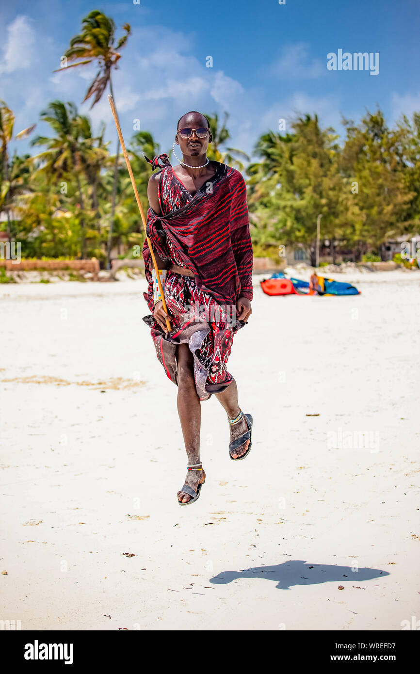 Masai in bright national clothes traditional jump on the beach Zanzibar Stock Photo