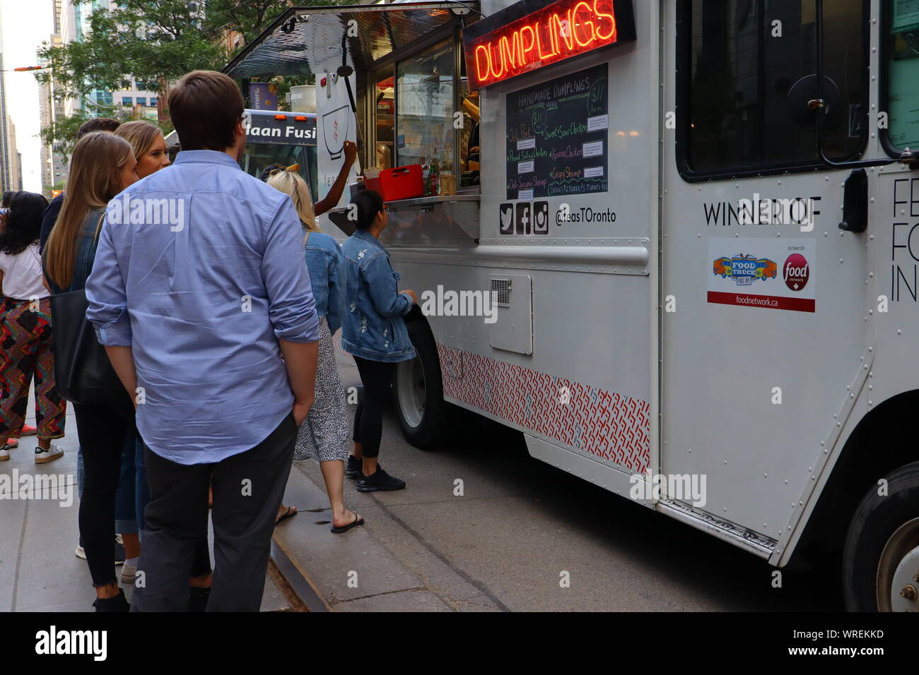 People line up to buy Chinese Dumplings from a food truck in Toronto during TIFF 2019. Stock Photo