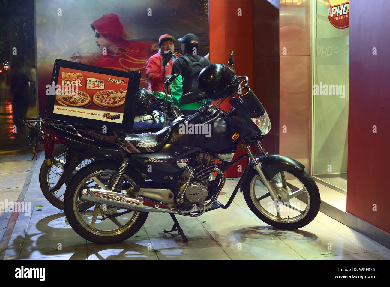 LIMA, PERU - MARCH 12, 2012: Motorbikes standing in front of PHD (Pizza Hut Delivery) on Jose Larco Avenue in Miraflores waiting to deliver Stock Photo