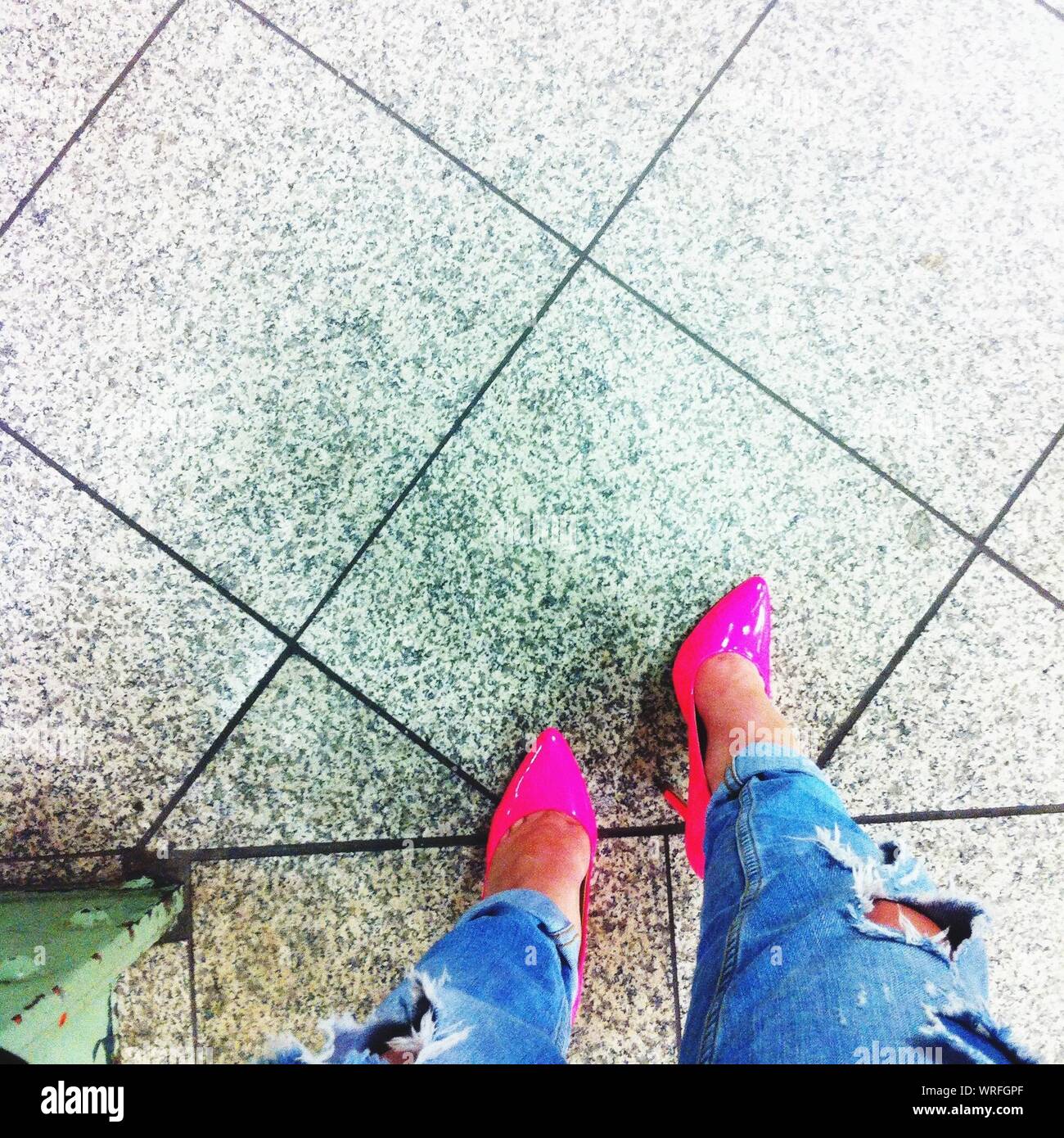 Woman's Legs With Torn Jeans And Pink High Heels Stock Photo - Alamy