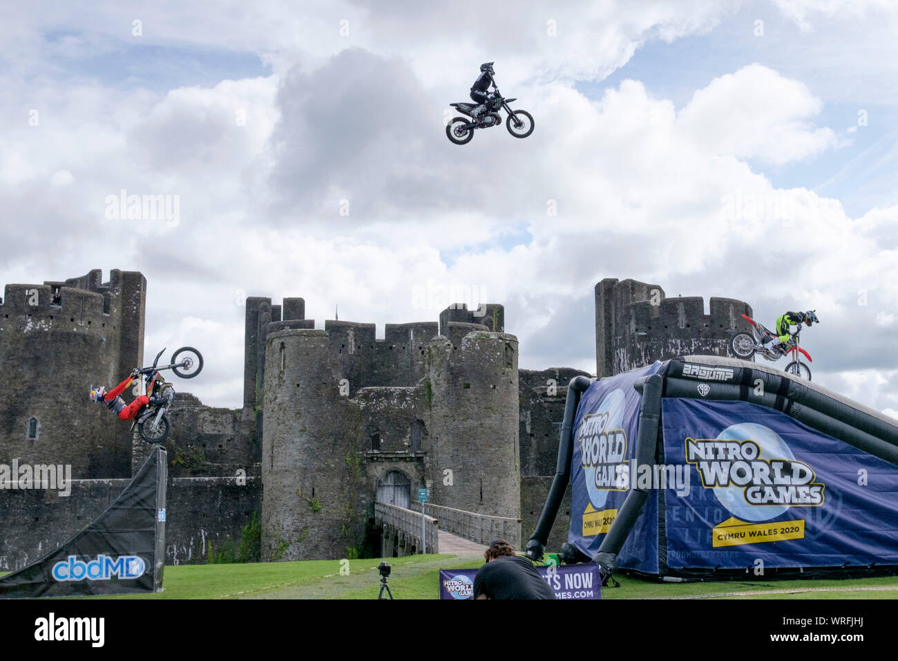Caerphilly, Wales, UK. 10th September 2019. Three Freestyle Motor Cross (FMX) stars perform the never seen before “synchronised double backflip train” in front of equally spectacular Caerphilly Castle. Stunt performers Jackson Strong, Josh Sheehan and Luc Ackerman, are amongst the most successful FMX stars in the world. The display promotes the upcoming 2020 Nitro World Games to be staged in the Principality Stadium in Cardiff. Credit: Mr Standfast/Alamy Live News Stock Photo